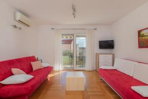 a living room with a red couch and a tv at Apartment Sunce in Promajna