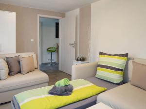 a living room with a couch and a yellow blanket at Apartment Hartmann by Interhome in Laudenau +20 photos