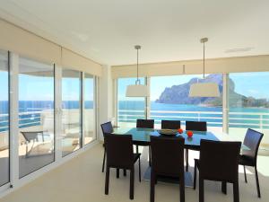 a dining room with a table and chairs with a view of the ocean at Apartment Esmeralda-1 by Interhome in Calpe