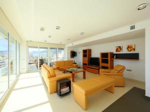 ein Wohnzimmer mit orangefarbenen Möbeln und einem TV in der Unterkunft Apartment Esmeralda-1 by Interhome in Calpe
