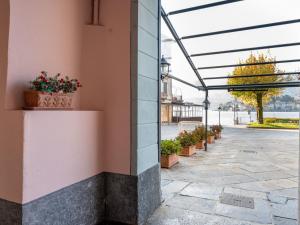 a building with potted plants on a patio at Apartment Borgo Vecchio by Interhome in Orta San Giulio