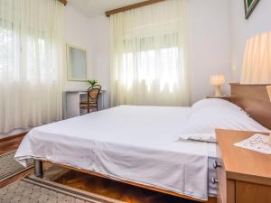 Schlafzimmer mit einem großen weißen Bett und einem Schreibtisch in der Unterkunft Holiday Home Ankica by Interhome in Pašman