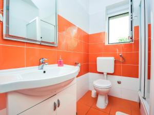 an orange bathroom with a sink and a toilet at Holiday Home Ankica by Interhome in Pašman +18 photos