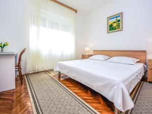 ein Schlafzimmer mit einem großen weißen Bett und einem Fenster in der Unterkunft Holiday Home Ankica by Interhome in Pašman