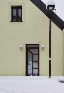 un bâtiment avec une porte dans la neige dans l'établissement Apartman_PidžuN, à Cetinje