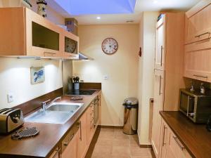 a kitchen with a sink and a clock on the wall at Holiday Home St Pierre by Interhome in Saint Malo