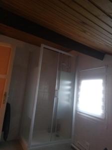 eine Glasdusche in einem Zimmer mit Fenster in der Unterkunft chez Doris et Alain in Lannemezan