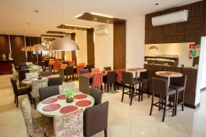 a dining room with tables and chairs in a restaurant at Carlton Plaza Torre in Araxá