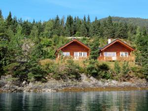 dois chalés de madeira na margem de um lago em Holiday Home Tyttebærhytta - FJH649 by Interhome em Onarheim