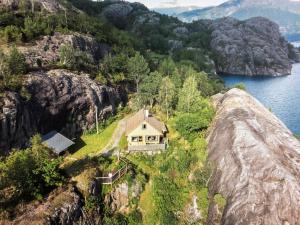 uma casa num penhasco junto à água em Chalet Åkrafjorden - FJH340 by Interhome em Åkra