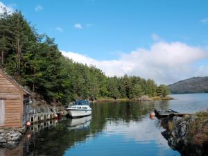 a boat is docked at a dock on a river at Holiday Home Blåbærhytta by Interhome in Onarheim