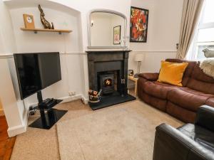 a living room with a couch and a fireplace at Tukes Cottage in Chipping Norton