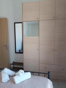 a bedroom with a closet and two towels on a bed at Retreat Apartments in Drosia - Apartment for 3 in Makris Gialos