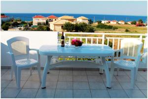 a blue table with two chairs and a bottle of wine at Retreat Apartments in Drosia - Apartment for 3 in Makris Gialos