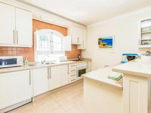 una cocina con armarios blancos y fregadero en Holiday Home Tejon by Interhome en Nerja