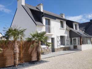 a white house with palm trees in front of it at Holiday Home Les Elfes by Interhome in Carnac