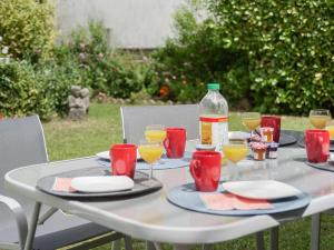 uma mesa branca com óculos e uma garrafa em Holiday Home La Coloniale by Interhome em Auray