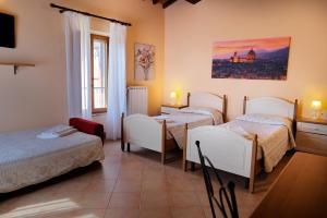 斯坎迪奇Agriturismo Villa Guarnaschelli的有三张床和一扇窗户的房间