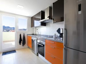 cocina con armarios de color naranja y nevera en Apartment Marina Park-2 by Interhome, en Denia