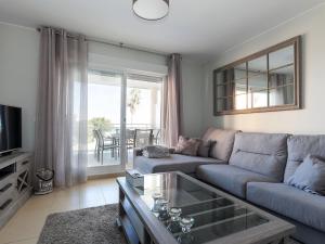 een woonkamer met een bank en een tv bij Apartment Marina Park-1 by Interhome in Denia