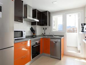 a kitchen with orange and gray cabinets and a window at Apartment Marina Park-1 by Interhome in Denia