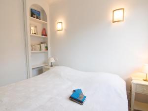 a book sitting on top of a white bed at Apartment Riva Bella-3 by Interhome in Cavalaire-sur-Mer