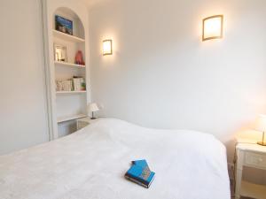 キャヴァレール・シュル・メールにあるApartment Riva Bella-3 by Interhomeの白いベッドの上に座る本