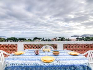 a table with chairs and a blue and white table cloth at Apartment Riva Bella-3 by Interhome in Cavalaire-sur-Mer