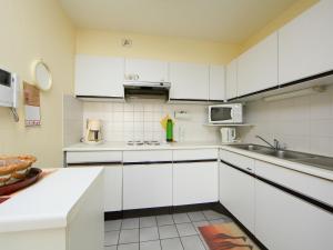 ブレーデネにあるApartment Residentie Astrid-4 by Interhomeの白いキャビネットとシンク付きのキッチン