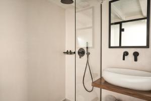 a bathroom with a sink and a glass shower at Almyra Guest Houses in Paraga