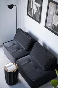 a black leather couch in a living room at Almyra Guest Houses in Paraga