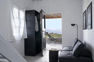 a living room with a couch and a sliding glass door at Almyra Guest Houses in Paraga