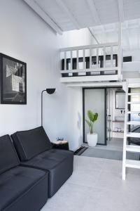 a living room with a black couch and a loft bed at Almyra Guest Houses in Paraga +37 photos