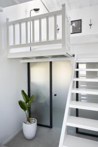a white staircase in a room with a plant at Almyra Guest Houses in Paraga