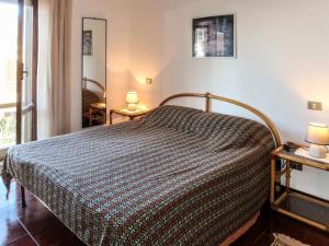 ein Schlafzimmer mit einem Bett und zwei Tischen mit Lampen in der Unterkunft Apartment Casa dei miei by Interhome in Civezza