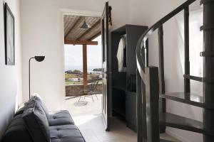 a living room with a couch and a stair case at Almyra Guest Houses in Paraga