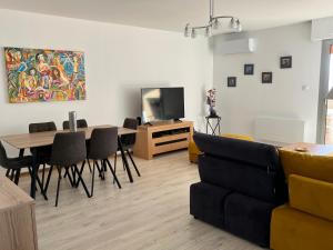 uma sala de estar com um sofá, uma mesa e uma televisão em Superbe 3 pièces vue mer sur les Sanguinaires em Ajaccio