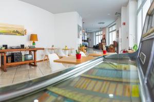 GuestHouse Lugano Center by LR في لوغانو: ممر بولينق في غرفة مع طاولات وكراسي