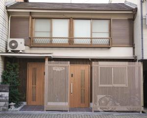 a house with wooden doors and a balcony at Tiz 海岸通り in Sumoto