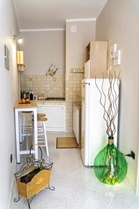 a kitchen with a white refrigerator and a table at A Casa di Nonna Ada in Manduria
