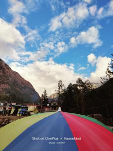 a red green and blue umbrella sitting on the ground at Breathe Inn in Kasol