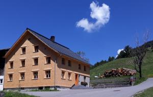 a large wooden building with a pile of logs at Pfefferhütte in Marul