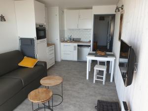 a living room with a couch and a table and chairs at Appartement Front de mer - Vue Ocean in Lacanau-Océan