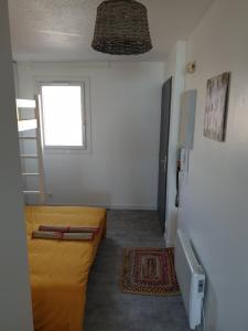 a small room with two beds and a window at Appartement Front de mer - Vue Ocean in Lacanau-Océan