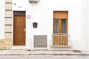a white house with two doors and a gate at A Casa di Nonna Ada in Manduria