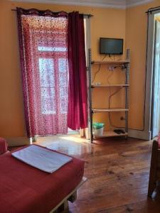 un soggiorno con divano rosso e finestra di Lisbon Angels Hostel a Lisbona