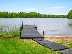 a wooden dock on the shore of a lake at Holiday Home Lehtikuusenranta by Interhome in Hankamäki
