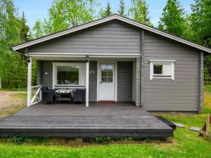 a gray house with a wooden deck in the yard at Holiday Home Lehtikuusenranta by Interhome in Hankamäki