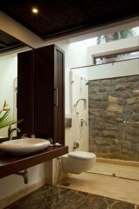 a bathroom with a sink and a toilet and a shower at The Serai Kabini in Begūr