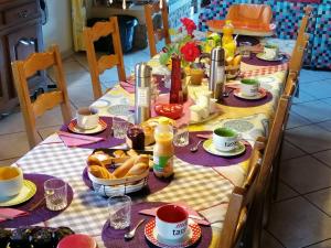 a dining table with food and drinks on it at Chambres D'Hôtes Vosges Chez Sylvia Et Luiggi in Pierrepont